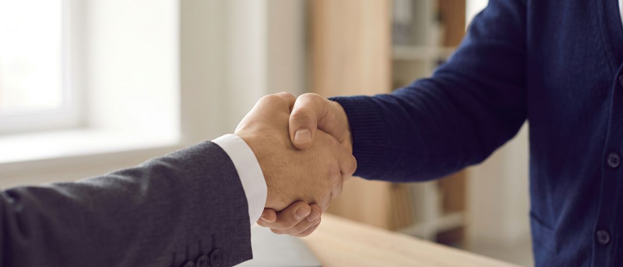A handshake across a desk
